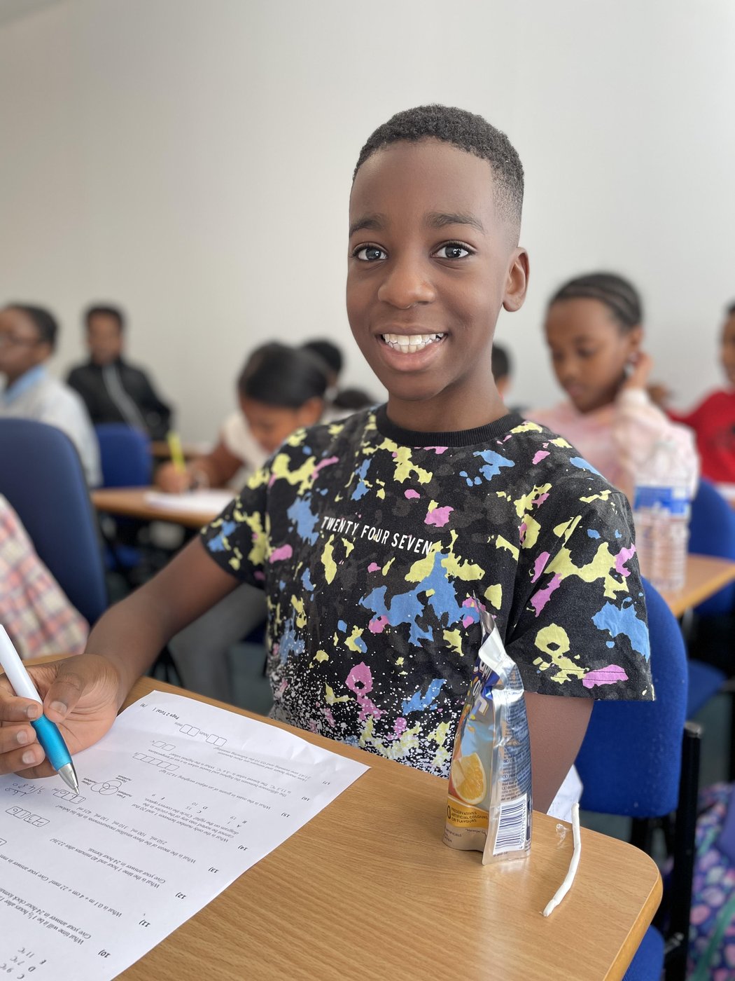 A smiling Bright Mentors student in a busy tuition class in Birmingham